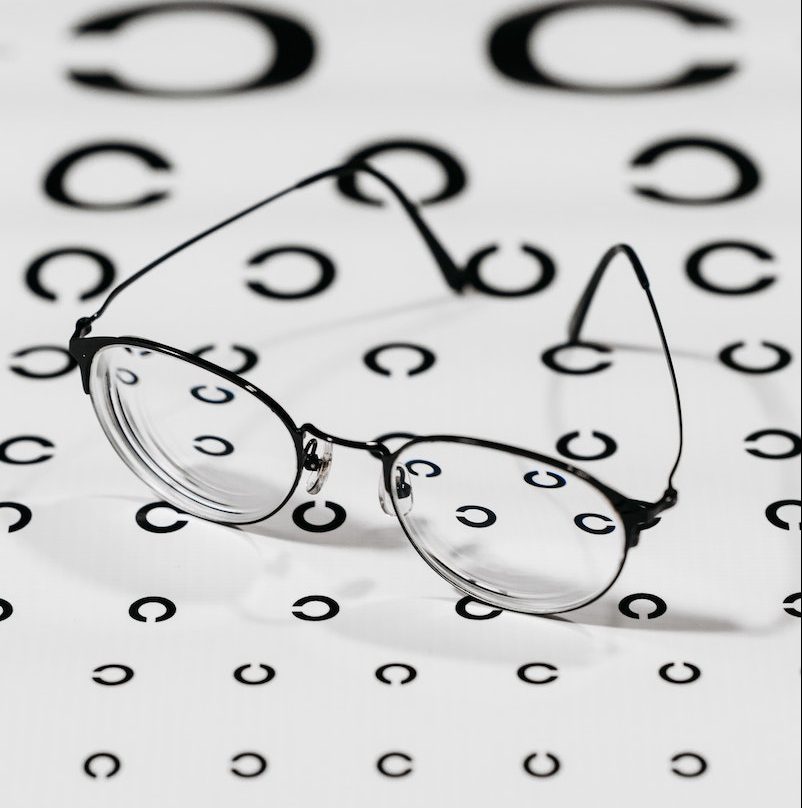 Black Framed Eyeglasses on White Paper With Printed Pattern